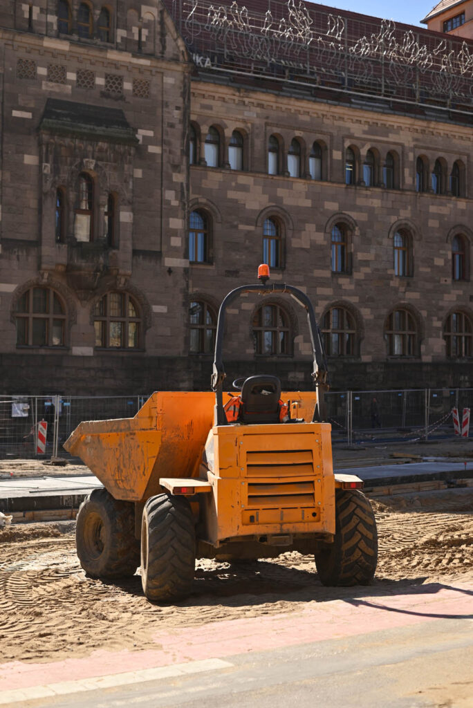 Small excavator on construction road. Tough heavy duty dump truc